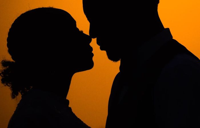 Silhouette of a man stretching against a sunset background.